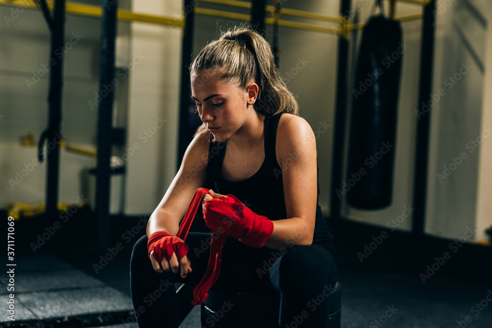 woman kickboxing puts bandages on her hands