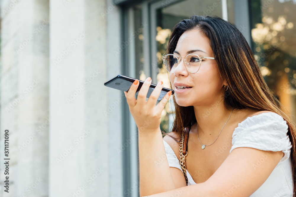 Fototapeta premium woman sends a voice message using her smartphone
