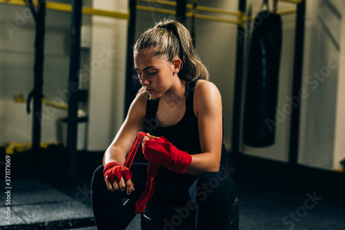 Fotografering woman kickboxing puts bandages on her hands