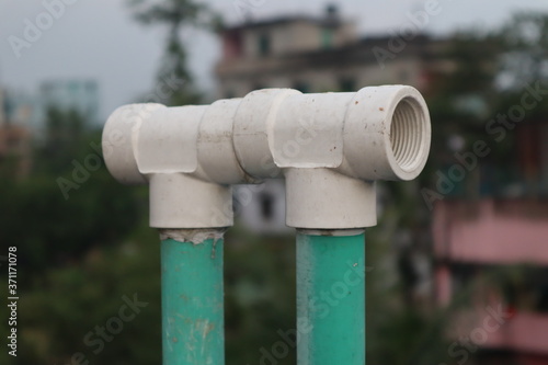 The white water pipe connector connects two green pipes.