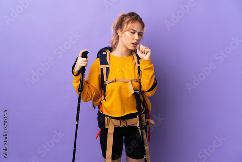 Teenager girl with backpack and trekking poles over isolated purple background coughing a lot