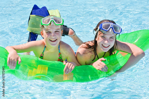 Zwei Mädchen im Wasser mit Luftmatraze und Taucherbrille