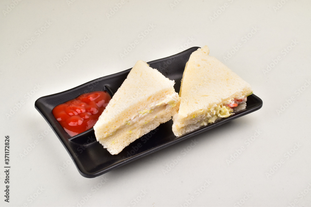 Fototapeta white bread sandwich with tomato ketchup in black plate isolated on white background