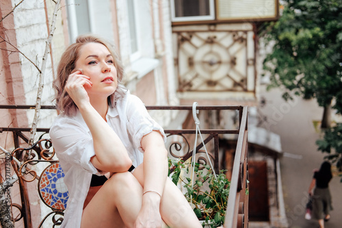 French balcony leisure time. Woman relaxing at home.