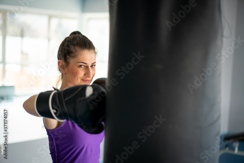 Pretty attractive woman kickboxing in gym