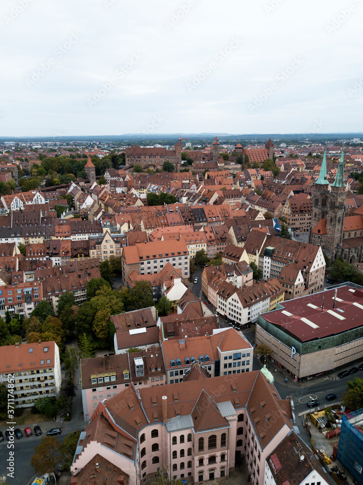 Obraz premium Aerial view of Nuremberg old town on Pegnitz river. Ancient buildings architecture half-timbered houses with red roofs. Cityscape rooftops. Trees. Germany. Europe.