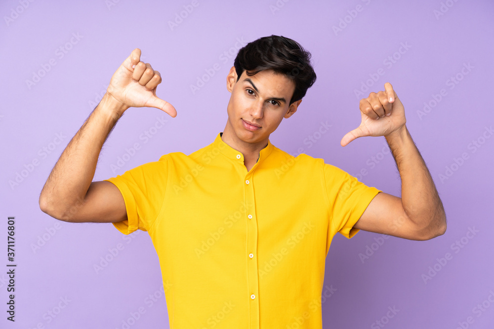 Man over isolated purple background showing thumb down Man over isolated purple background showing thumb down