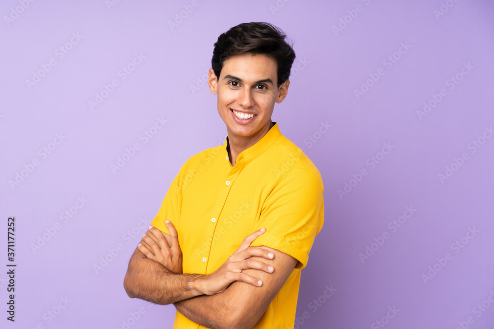 Man over isolated purple background with arms crossed and looking forward Man over isolated purple background with arms crossed and looking forward