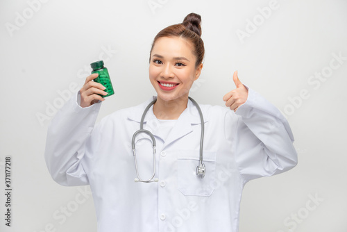 happy woman showing thumb up and holding bottle with pills