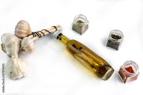 glass bottle of extra virgin oil with thyme, garlic and pepper