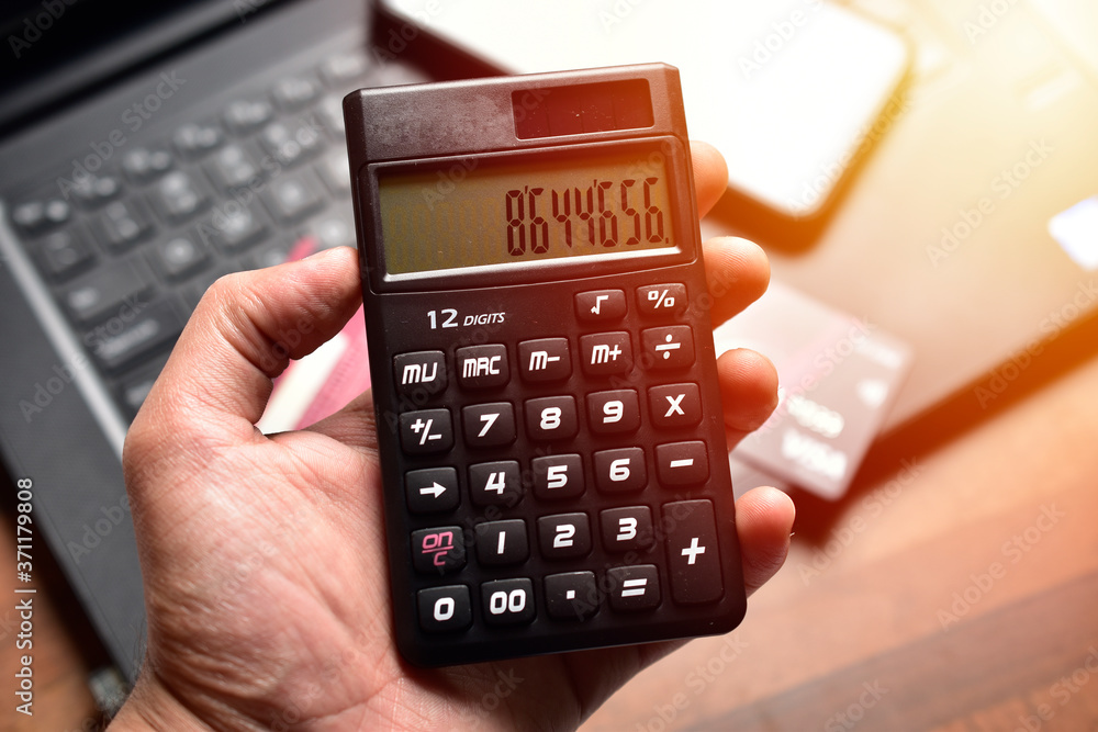Obraz premium hand holding calculator in office, business concept