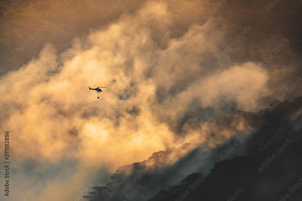 Fire fighting helicopter carry water bucket to extinguish the forest fire Fire fighting helicopter carry water bucket to extinguish the forest fire