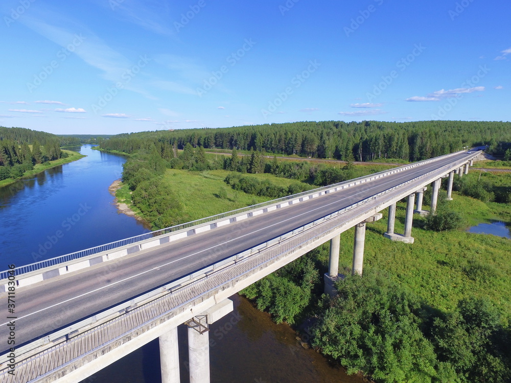 Bridge over the Ukhta river and blue sky, Komi Republic, Russia.
