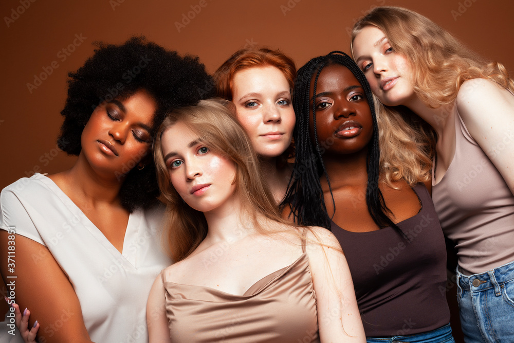 Obraz premium young pretty caucasian, afro, scandinavian woman posing cheerful together on brown background, lifestyle diverse nationality people concept
