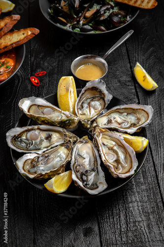 Oysters with sauce on a black board table