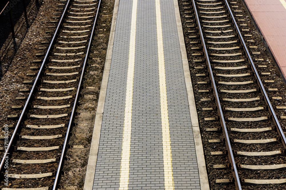 Railway top view background. Train transport industry. Rail track texture. Good and cheap way of transportation for cargo. Track ballast gravel made of crushed stone. Empty train station platform.