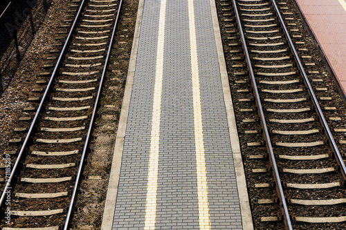 Railway top view background. Train transport industry. Rail track texture. Good and cheap way of transportation for cargo. Track ballast gravel made of crushed stone. Empty train station platform.