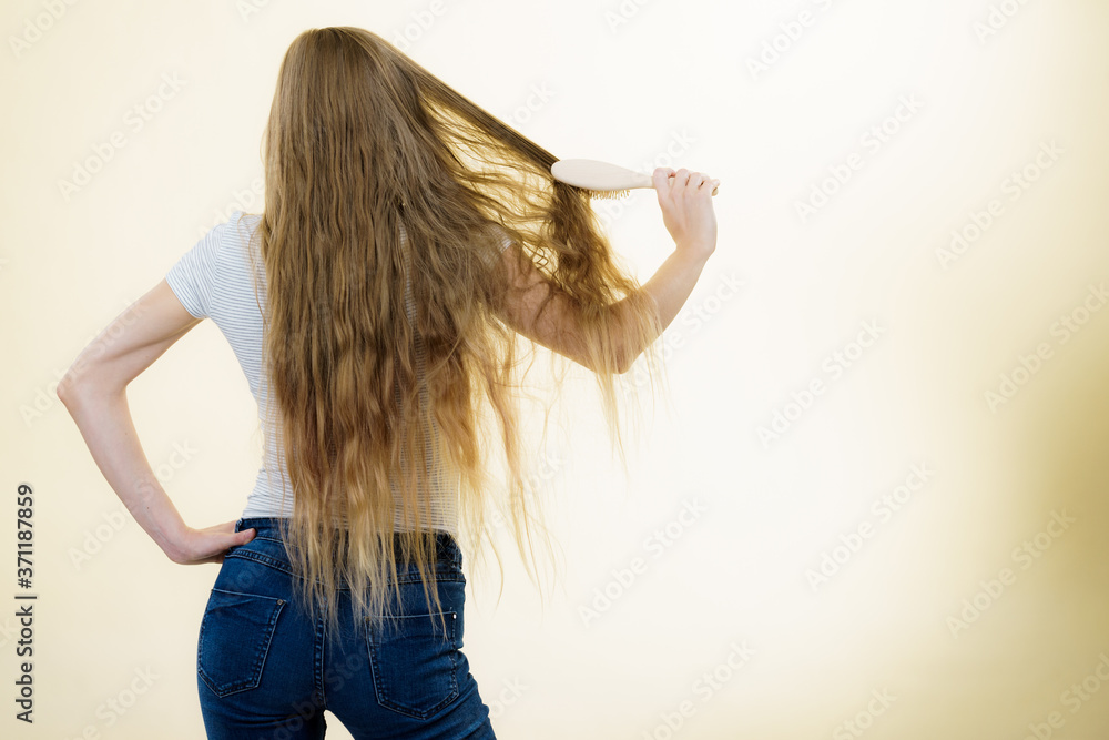 Fototapeta premium Blonde girl brushing her long hair
