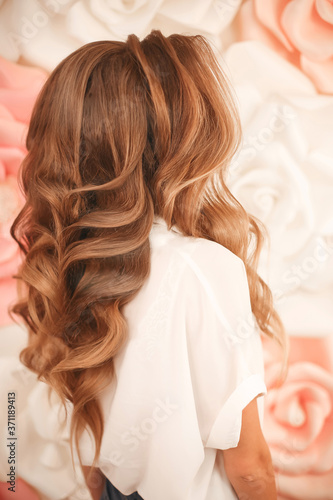 Healthy hair. Wavy long hairstyle. Back view of Blond hair styling. Wedding day. Bride. High Fashion Coiffure. Close Up of Hairdo