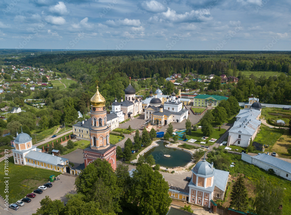 Aerial summer view of white old monastery with golden domes in Russia.