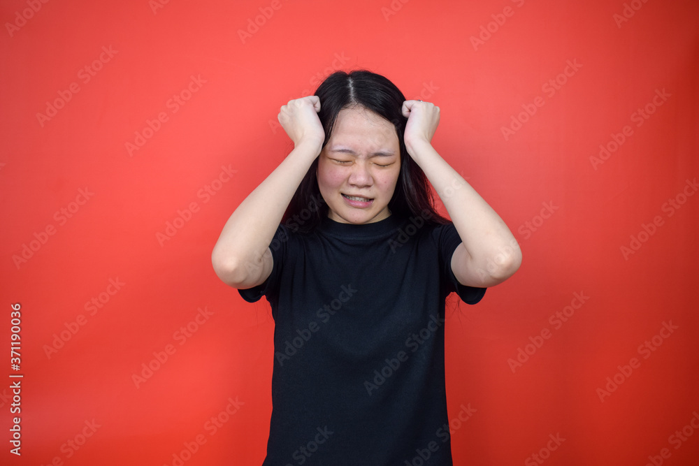 Portrait of Young beautiful asian woman using black T-shirt with red isolated background Portrait of Young beautiful asian woman using black T-shirt with red isolated background