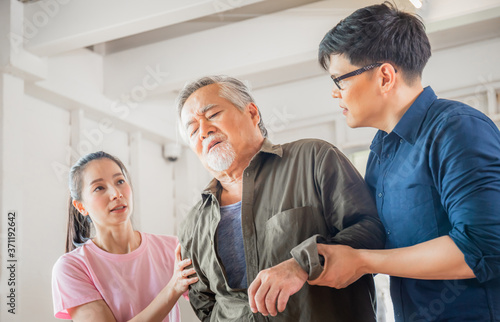 Son and daughter help support a senior father have a backache, Back pain in elderly adults, Asian family concepts