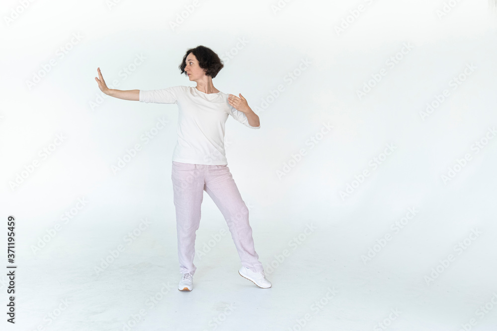 woman practicing qi qong at white studio traditional chinese gymnastics woman practicing qi qong at white studio traditional chinese gymnastics