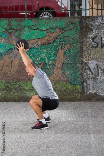 Sportist working out with a medicine ball outdoors. photo