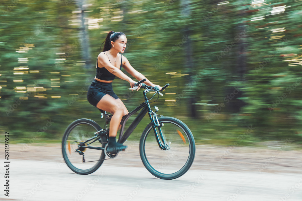 girl quickly rides a bicycle in the forest girl quickly rides a bicycle in the forest