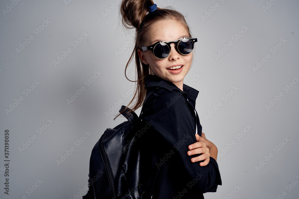 Cute schoolgirl wearing sunglasses childhood learning school light background