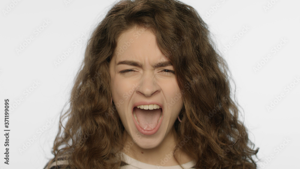 Angry woman screaming in studio. Portrait of rage girl scream on white