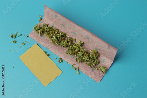 Joint paper for cannabis roll on blue background top view, marijuana smoking accessory