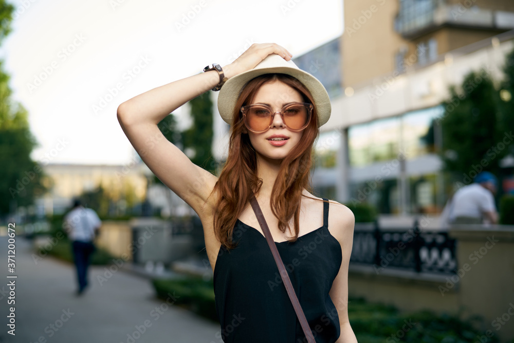 fashionable woman on city street in black dress and hat glasses makeup model watch on hand fresh air