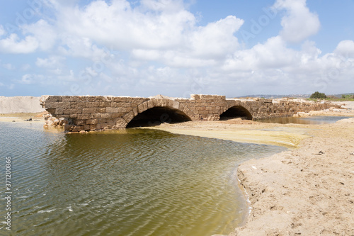 Remains  of a bridge across Nahal Taninim River - Crocodile River near ruins of Turris Slinarum - Salt Tower fortress near to Jisr Ez Zarqa arab village. Located near the Atlit city in northern Israel photo