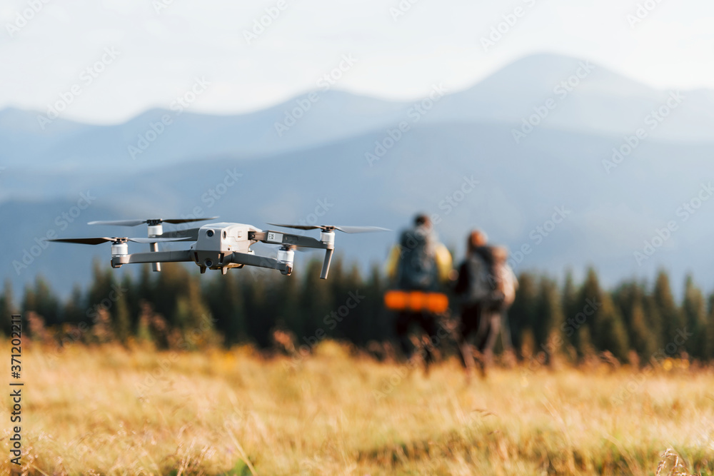 Drone flying near young travelers. Majestic Carpathian Mountains. Beautiful landscape of untouched nature Drone flying near young travelers. Majestic Carpathian Mountains. Beautiful landscape of untouched nature