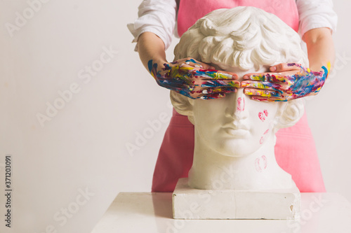 Gypsum statue of Antinous head. Plaster statue in woman's hands. Concept photography about art and gender. Copy space photo