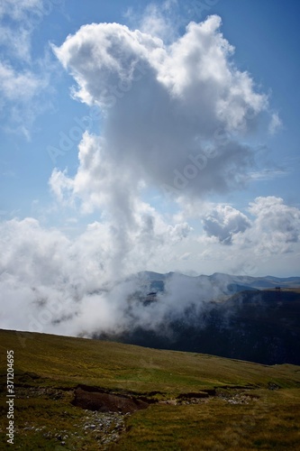 fluffy white clouds among the mountain ridges. mist at high altitude