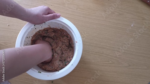 Tableau sur toile Minced steak, meatballs making, hand kneading meat mixture in the pot