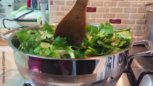 Fotografie Chef mixing fresh cut green vegetables on frying pan