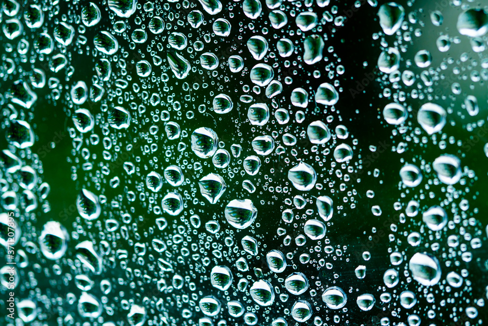 Macro raindrops vapor on window glass. Rain drops on window glasses surface. Through the window view. Drops of rain on glass. Water pattern texture Macro raindrops vapor on window glass. Rain drops on window glasses surface. Through the window view. Drops of rain on glass. Water pattern texture
