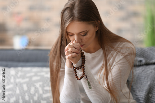 Fotografie Beautiful young woman praying at home