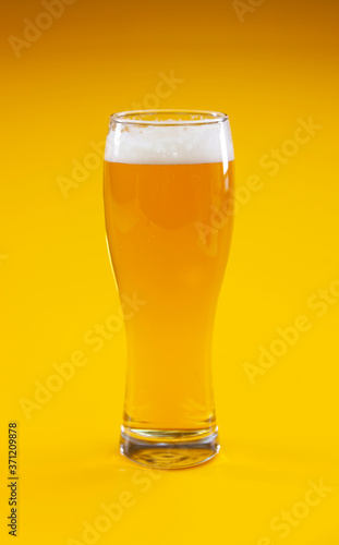 Glass of beer on yellow background