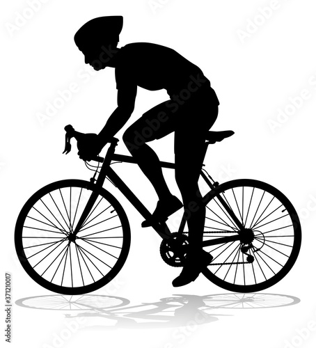 Fototapeta Naklejka Na Ścianę i Meble -  Bicyclist riding their bike and wearing a safety helmet in silhouette