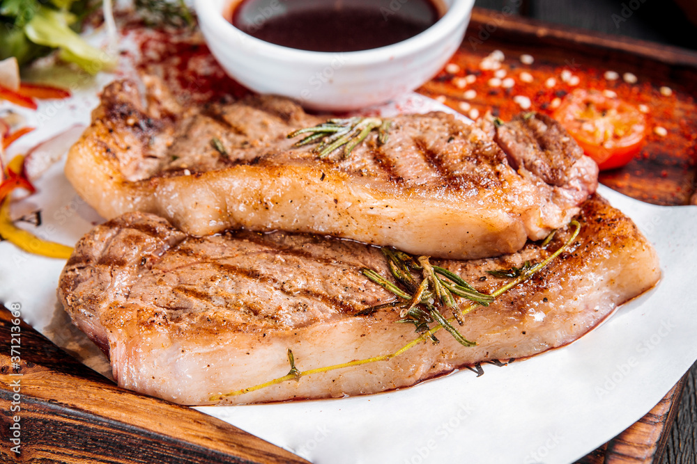 Closeup on grilled juicy steaks with rosemary Closeup on grilled juicy steaks with rosemary