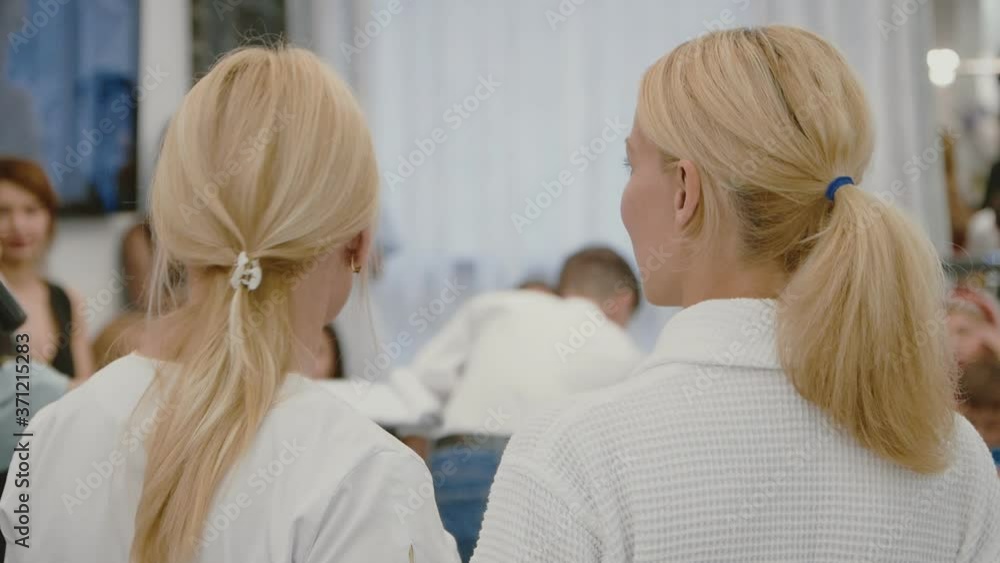two lesbian girls in white coats are embracing at the presentation of a new cosmetology hardware method for skin and body care. LGBT.back view two lesbian girls in white coats are embracing at the presentation of a new cosmetology hardware method for skin and body care. LGBT.back view