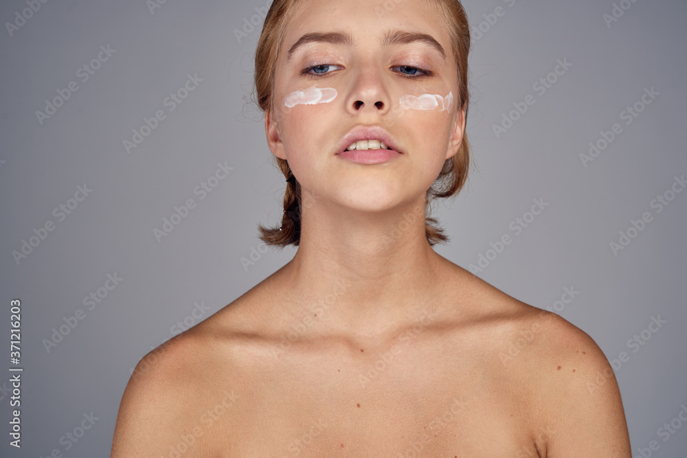 woman blonde with bare shoulders clear skin face naked shoulders cream spa salon gray background woman blonde with bare shoulders clear skin face naked shoulders cream spa salon gray background