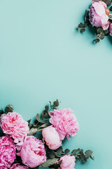 Floral pattern, frame made of pink peonies, eucalyptus flowers on pastel blue background. Flat lay, top view. Copy space. Wedding, birthday, anniversary bouquet. Valentine's, Woman day, Mother's day.