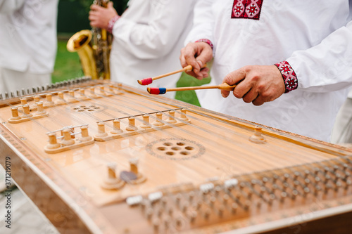 Close-up a dulcimer which Thai traditional music instrument. Man playing hammered dulcimer with mallets. Wedding musician. photo