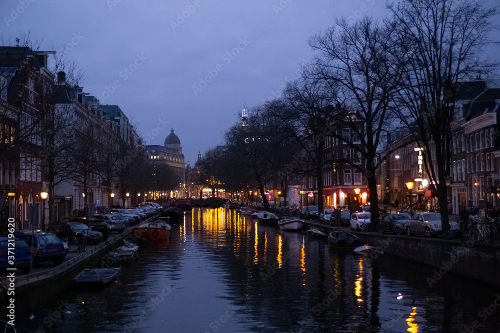 night street, a lighted street reflected in the water in Amsterdam in the Netherlands