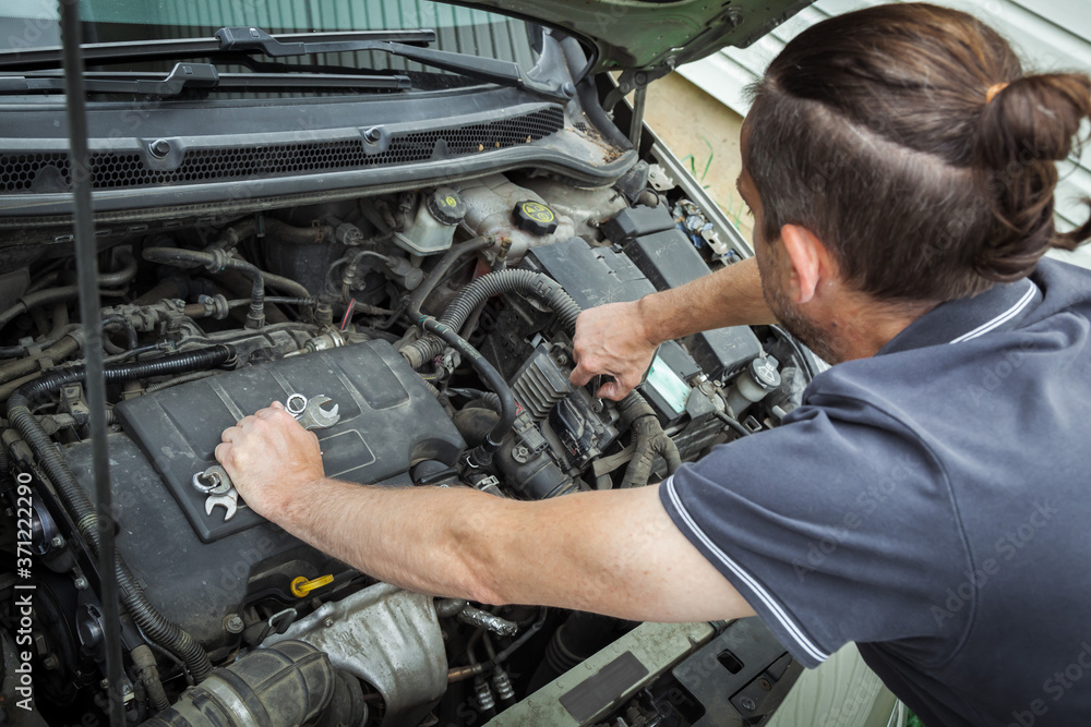 Close-up Of Hand Repairing Car Engine. Close-up Of Hand Repairing Car Engine.